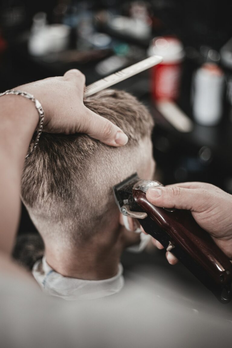 Barbero cortando el pelo a máquina en la nuca de un cliente